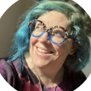 woman with blue hair wearing glasses looking off into the distance business writing services